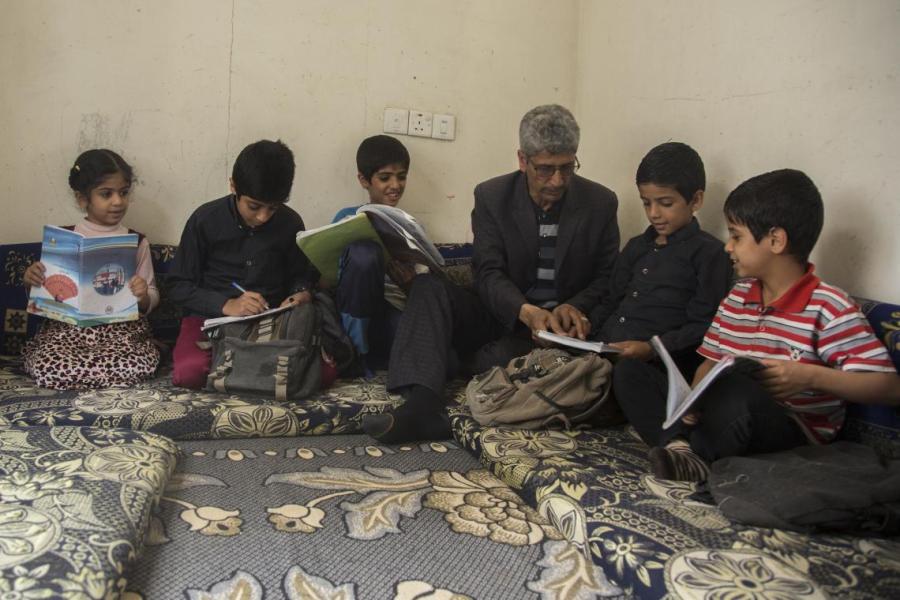Hamoud Hassan helps his children with their homework