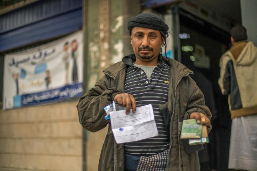 Faisal receiving the cash transfer at the payment site of Dhamar city