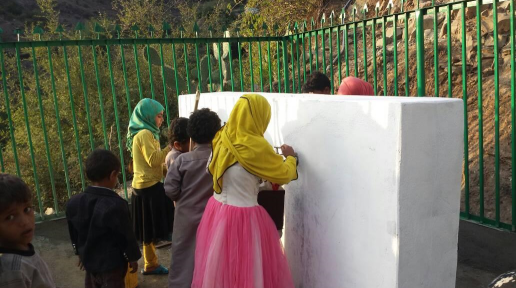 Girls fetching water from water reservoir closed to the village